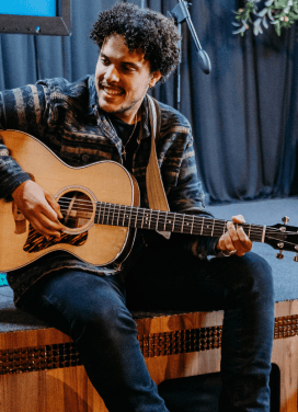 Darryll Stinson playing acoustic guitar at a live event.
