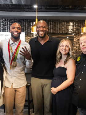 Darryll Stinson smiling with event attendees at a professional gathering.