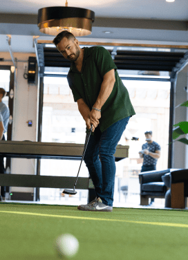 Man playing indoor golf at the Events, Darryll Stinson.