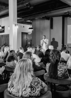 Darryll Stinson speaking at a professional event, engaging an audience in a modern venue.